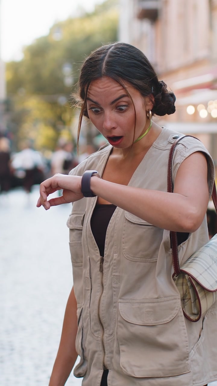 Donna confusa che si preoccupa di essere puntuale con ansia che controlla l'ora di guardia che arriva in ritardo al lavoro