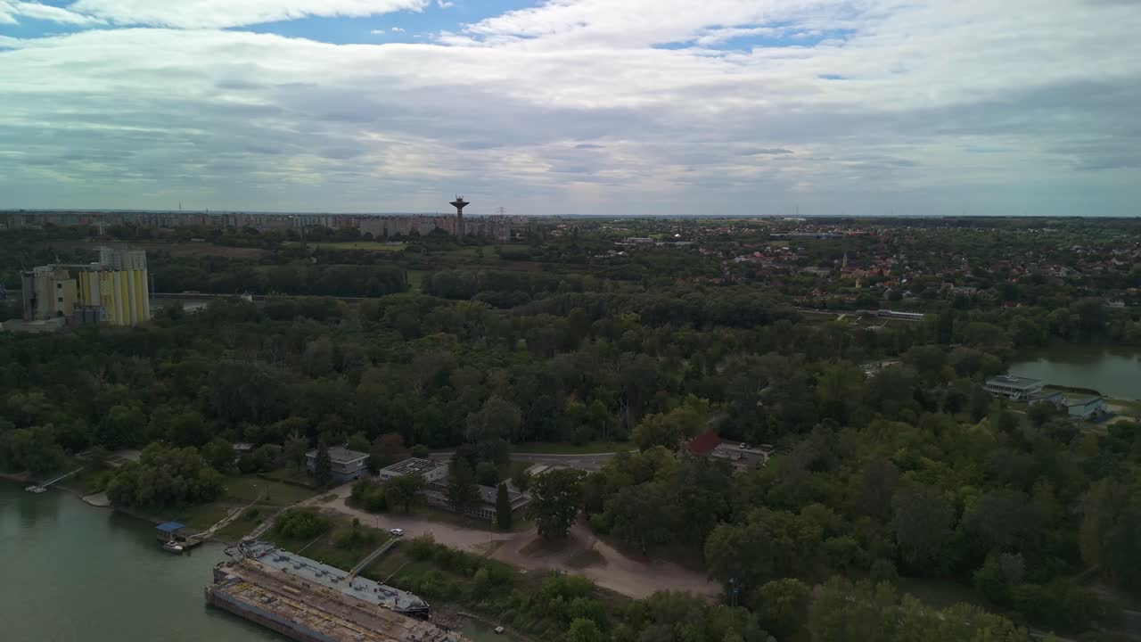 Orbital aerial view of Dunaújváros suburb with the block of houses and industrial facilities in the background along the Danube River in Hungary