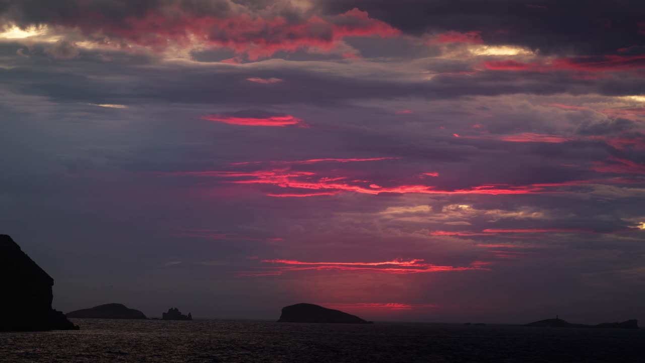 Panoramaoptagelse af glødende solnedgangsskyer over Cala Comte-horisonten på Ibiza