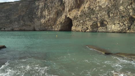 Mediterranean-Sea-Waves-Washing-Shore-Filled-with-Pebbles-near-Inland-Sea-Caves