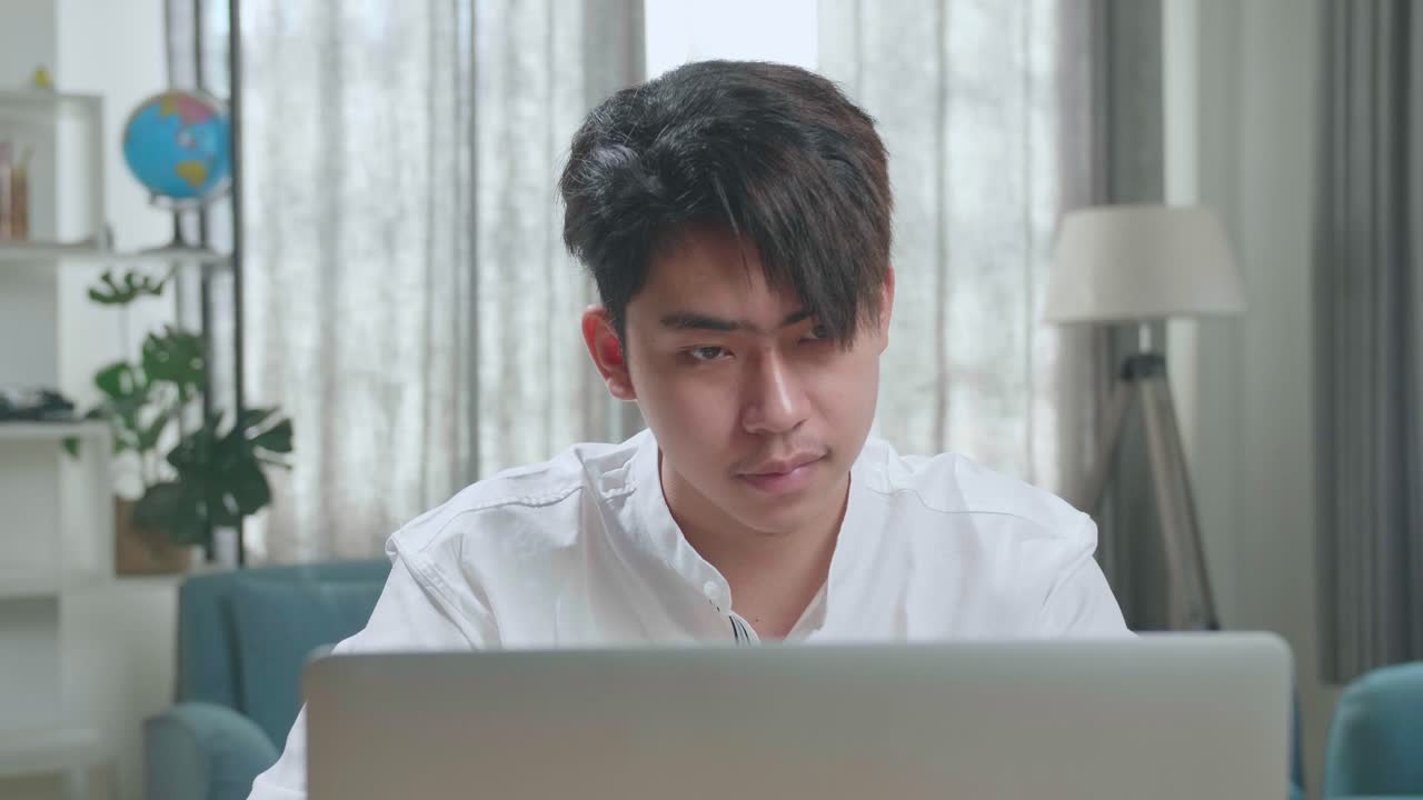 Close Up Of A Happy Asian Man Student Using Computer To Study Online At Home