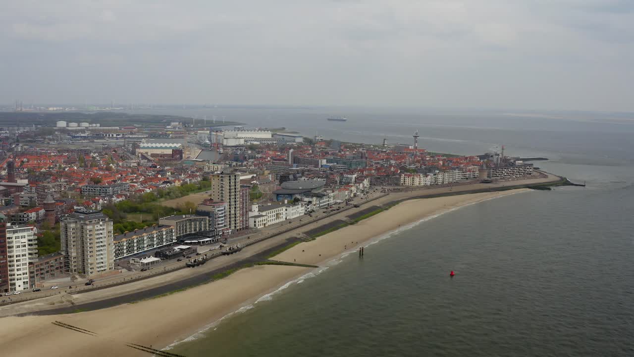 órbita aérea a gran altitud sobre la playa vacía de la ciudad y el horizonte frente al mar en vlissingen, países bajos