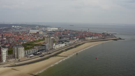 Luftumlaufbahn-In-Großer-Höhe-über-Dem-Leeren-Stadtstrand-Und-Der-Skyline-Am-Wasser-In-Vlissingen,-Niederlande