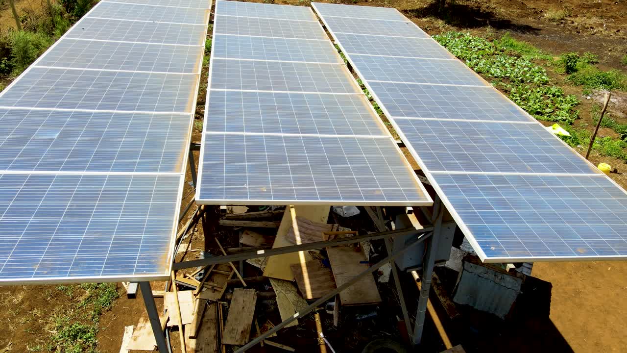 Luftfoto fra drone af store solpaneler på en solcellepark ved klar solnedgang
