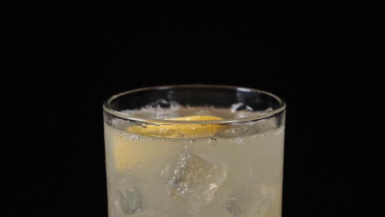 trozos de limón cayendo en vaso