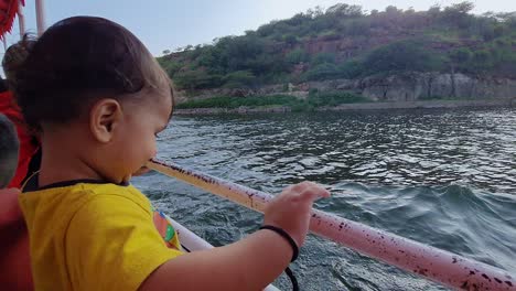 toddler enjoying boat ride at river from flat angle at day