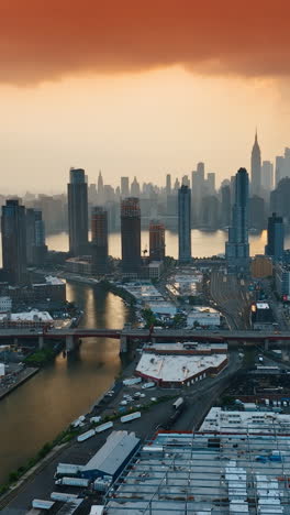 lively city of new york from aerial perspective. pink cloudscape in the sky above the metropolis. mighty skyscrapers towering above the river. vertical video