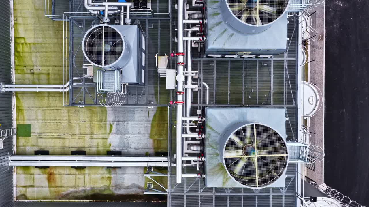 Top down view of industrial HVAC cooling towers on the building roof