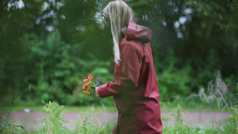 Seitenansicht-Einer-Holländischen-Frau,-Die-Mit-Frisch-Gepflückten-Blumen-In-Den-Niederlanden-Durch-Den-Park-Spaziert-–-Mittlere-Zeitlupenaufnahme