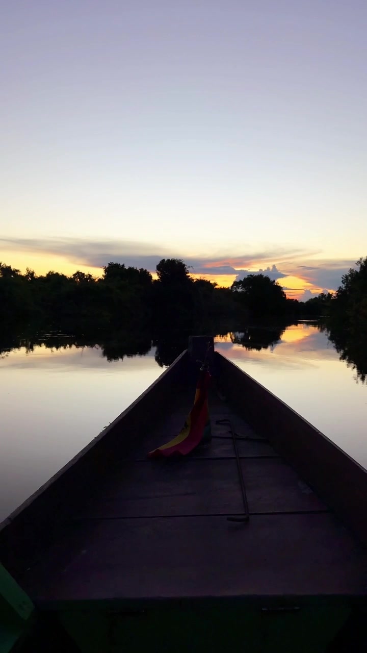 Traditional wooden boat navigation at dusk in Bolivian Amazon