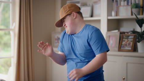 funny teenager boy with down syndrome dancing in living room special needs kid having fun celebrating with silly dance moves enjoying happy weekend at home 4k