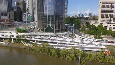 traffic on highway exchange on ramp next to river and downtown district of brisbane