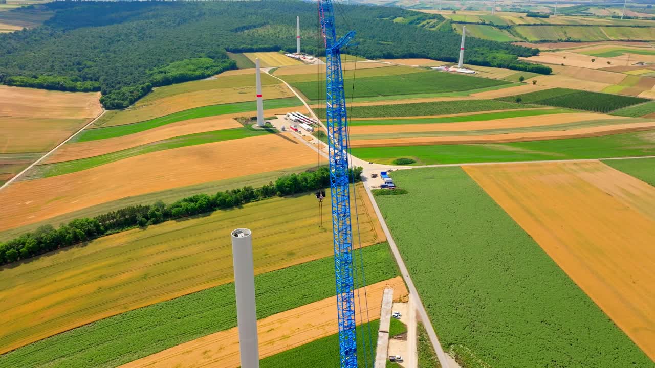 grúa torre en el ensamblaje de la turbina eólica en la tierra de cultivo en austria