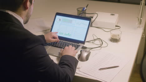 caucasian bearded man working in office while typing on laptop