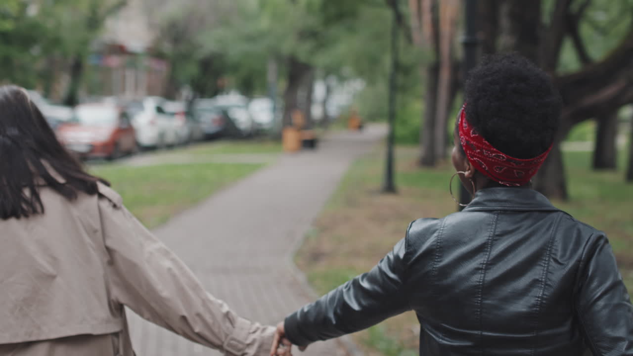Felice coppia LGBTQ che ride e balla in un parco