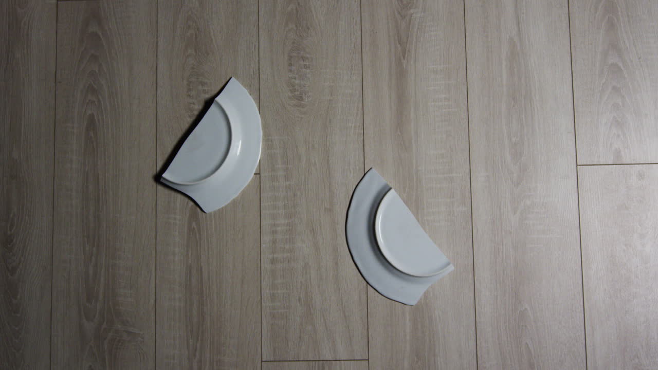 접시가 바닥으로 떨어지고 산산조각이 나고 슬로우 모션 미디엄 샷