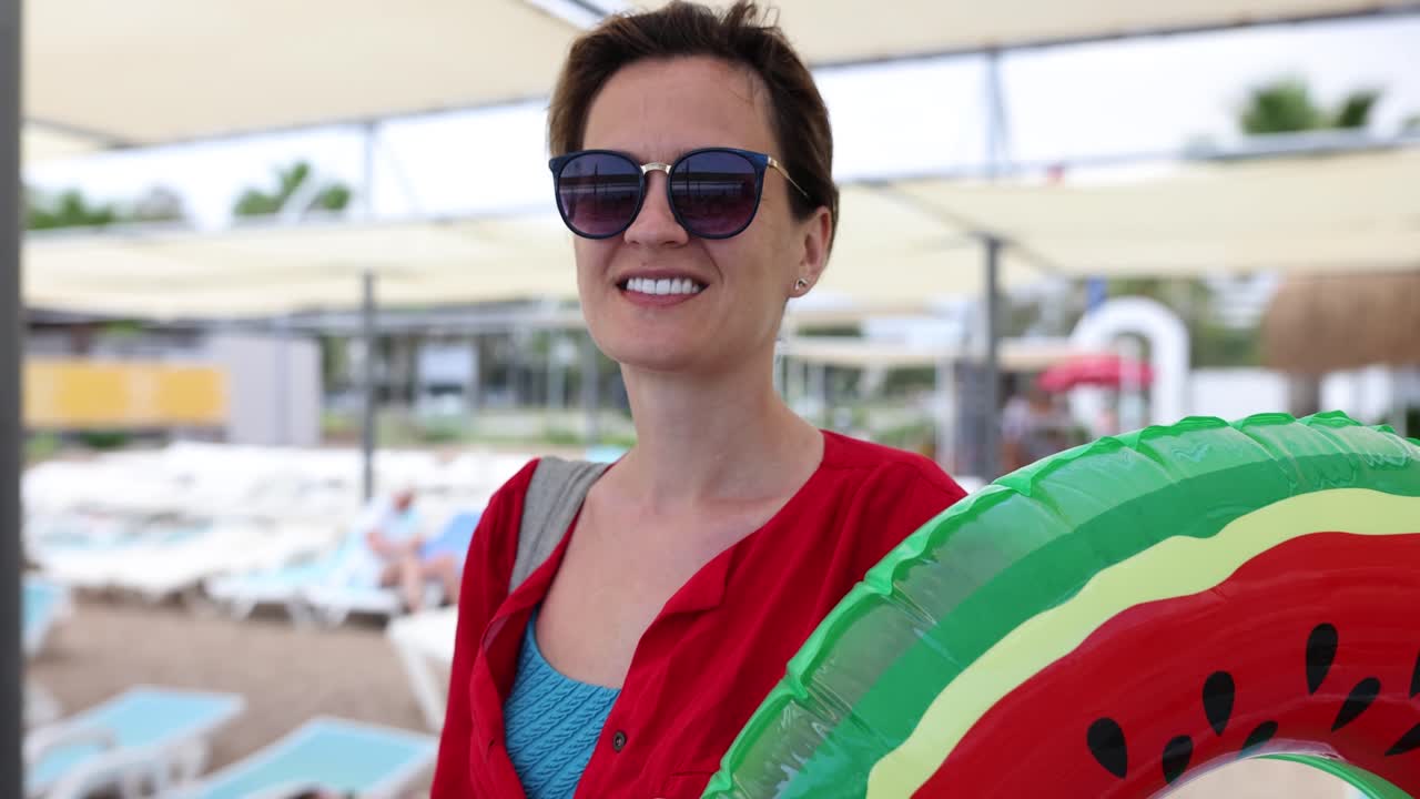 Smiling Woman with Watermelon Swim Ring at a Beach Resort