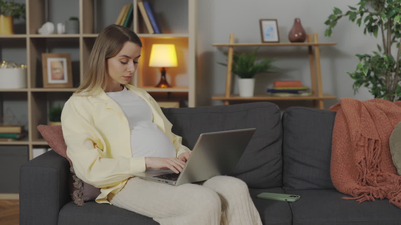 Pregnant woman working from home on laptop