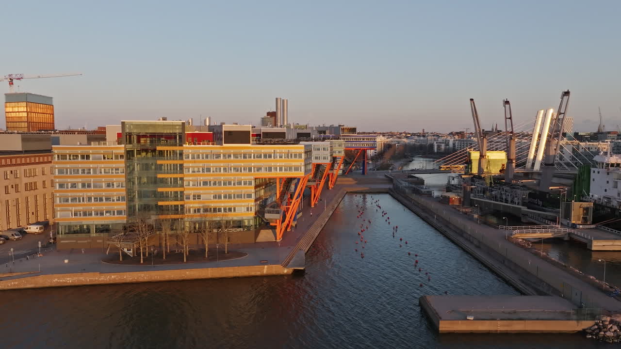 Aerial tracking shot of the harbor in Salmisaari, sunny evening in Helsinki, Finland