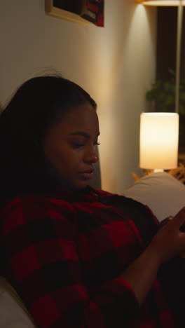 woman using phone in a dark bedroom