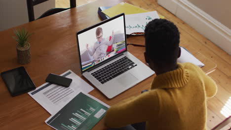 maestra afroamericana usando una computadora portátil en una videollamada con un escolar