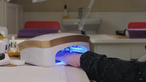 woman getting her nails dried in a nail salon.