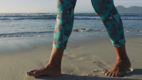 low section of senior african american woman walking at the beach