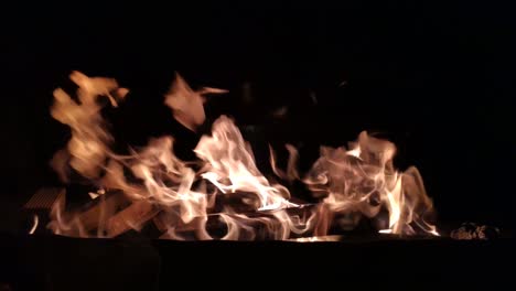 blacksmith-forge-with-strong-fire-flames-produced-with-charcoal-fuel-and-wood-in-the-dark-of-night,-shot-blocked-close-up,-Galicia,-Spain