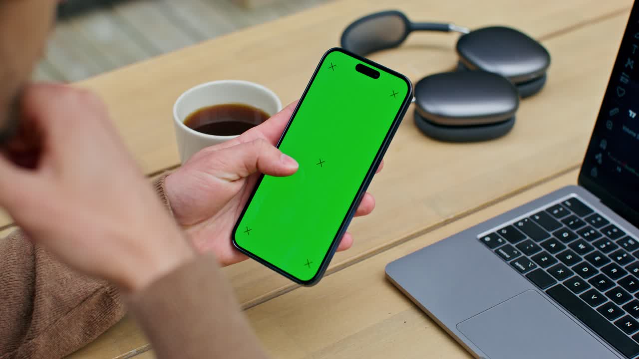 persona que sostiene un teléfono inteligente con pantalla verde