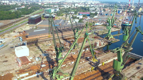 aerial flyover old harbor of gdansk with cranes and docks in sunlight - poland,europe