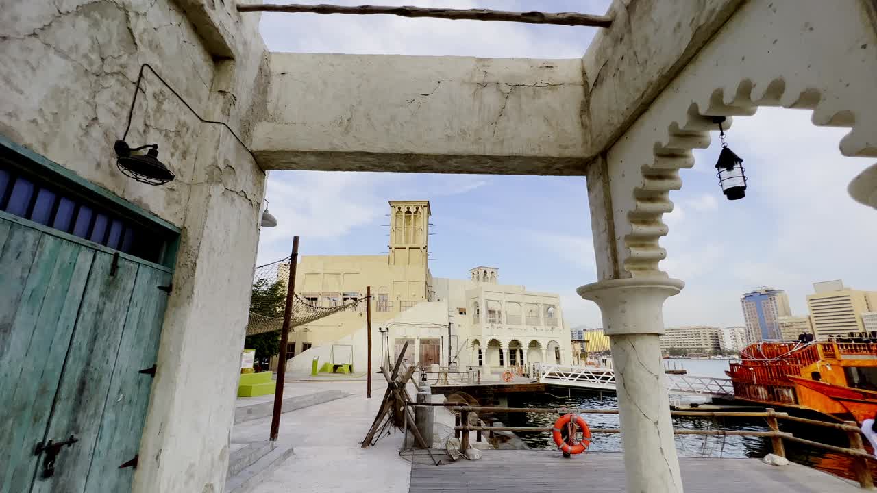 edificio tradicional con torre de viento a lo largo de dubai creek en el barrio histórico de al fahidi en dubai, emiratos árabes unidos