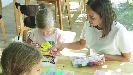 children learning beading art with a mother