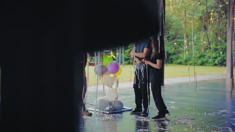 people setting up or cleaning up after an event with streamers and balloons