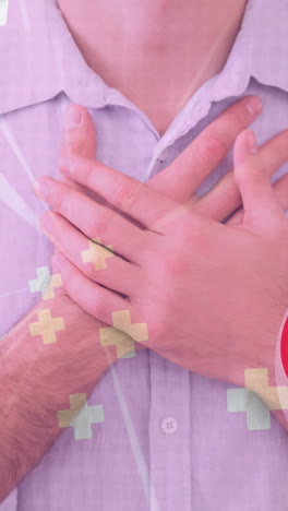 animation of heart and crosses icons over caucasian man holding his chest