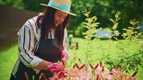 woman in striped shirt and hat tending to vibrant flowers in a sunny garden setting