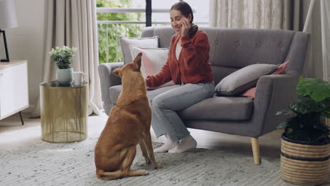 woman training her dog in living room