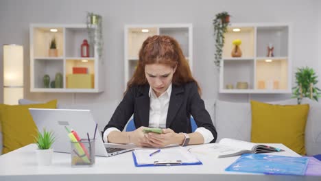 la mujer que trabaja en la oficina se frustra mientras mira el teléfono.