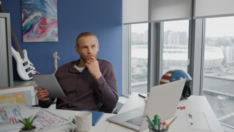 Pondering-designer-thinking-tablet-at-home-close-up.-Pensive-man-holding-pad