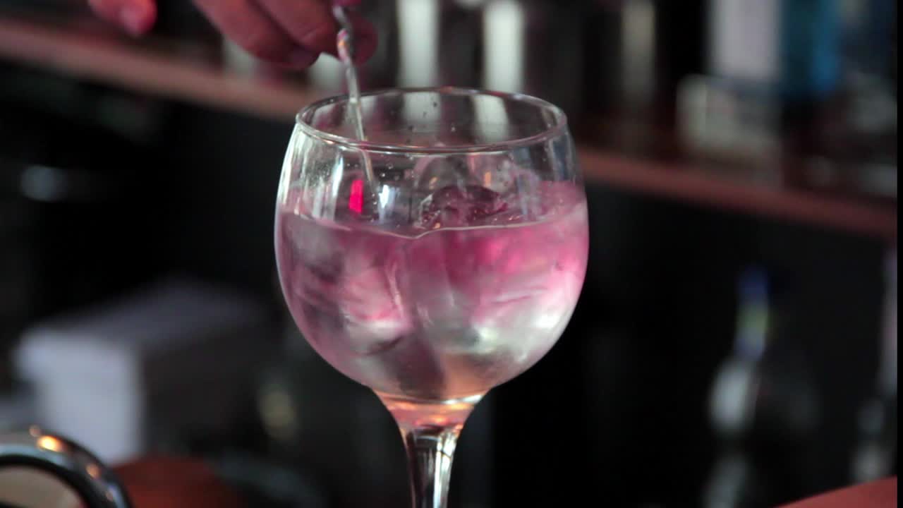 Barman che mescola ghiaccio e whisky con un cucchiaio da bar