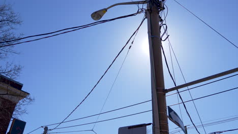 Sol-Brillante-Que-Brilla-A-Través-De-Los-Cables-De-Un-Poste-Eléctrico