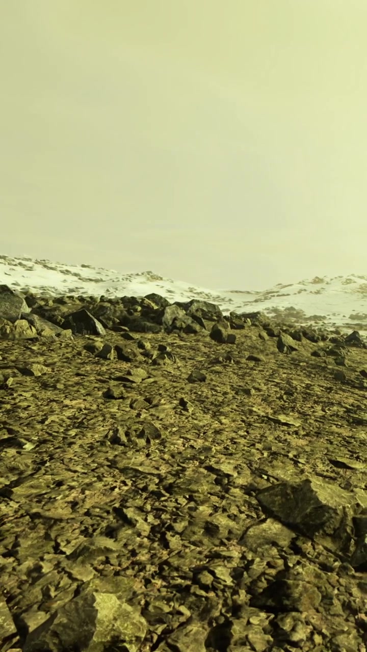 Landscape view showing rocky terrain with snow under a cloudy sky at twilight