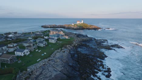 aerial drone shot of york beach maine flying towards cape neddick nubble lighthouse at sunset