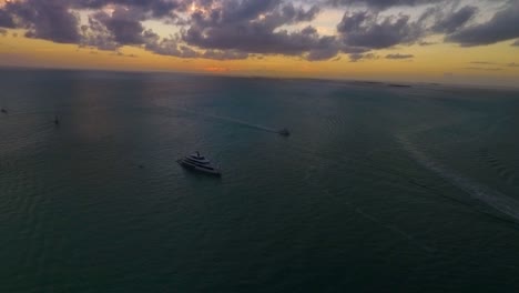 un gran yate navega mientras se pone el sol: todo capturado a través de un dron en una resolución nítida de 4k