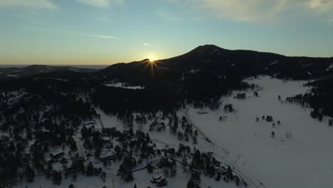 evergreen meadows marshdale sun flare conifer colorado aerial drone scenic golden cold sunrise early morning winter snow valley forest december rocky mountains town front range backwards motion