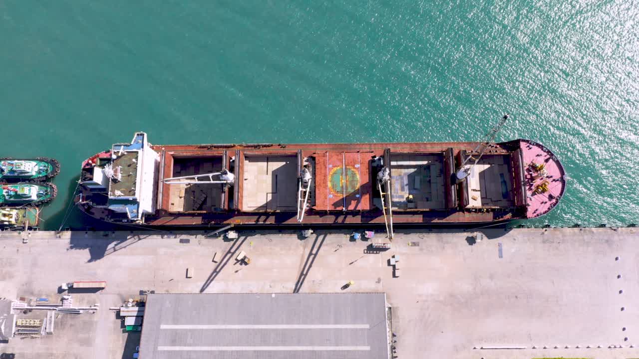 Aerial drone top view of containers cargo ship at industrial import-export port. Business logistic import and export freight transportation by container ship in open sea