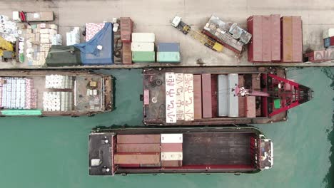 pequeñas barcazas de contenedores de tipo alimentador que operan en el muelle de pilar de hong kong