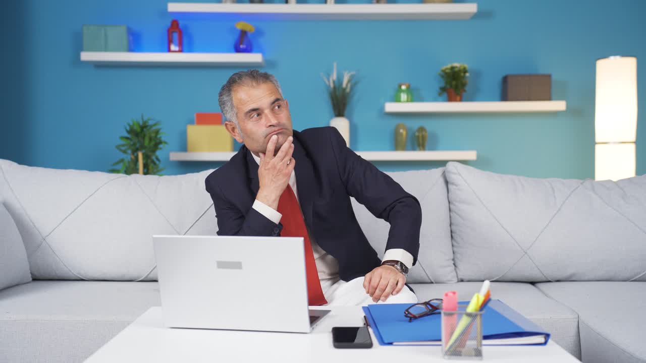 가정 사무직 노동자 남자가 카메라를 쳐다보며 생각하고 있습니다.