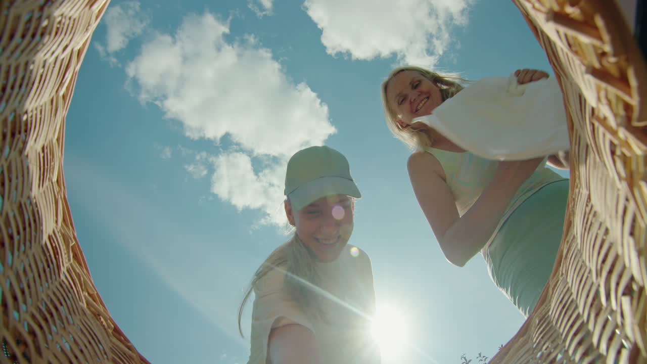 мать и дочь кладут белье в корзину