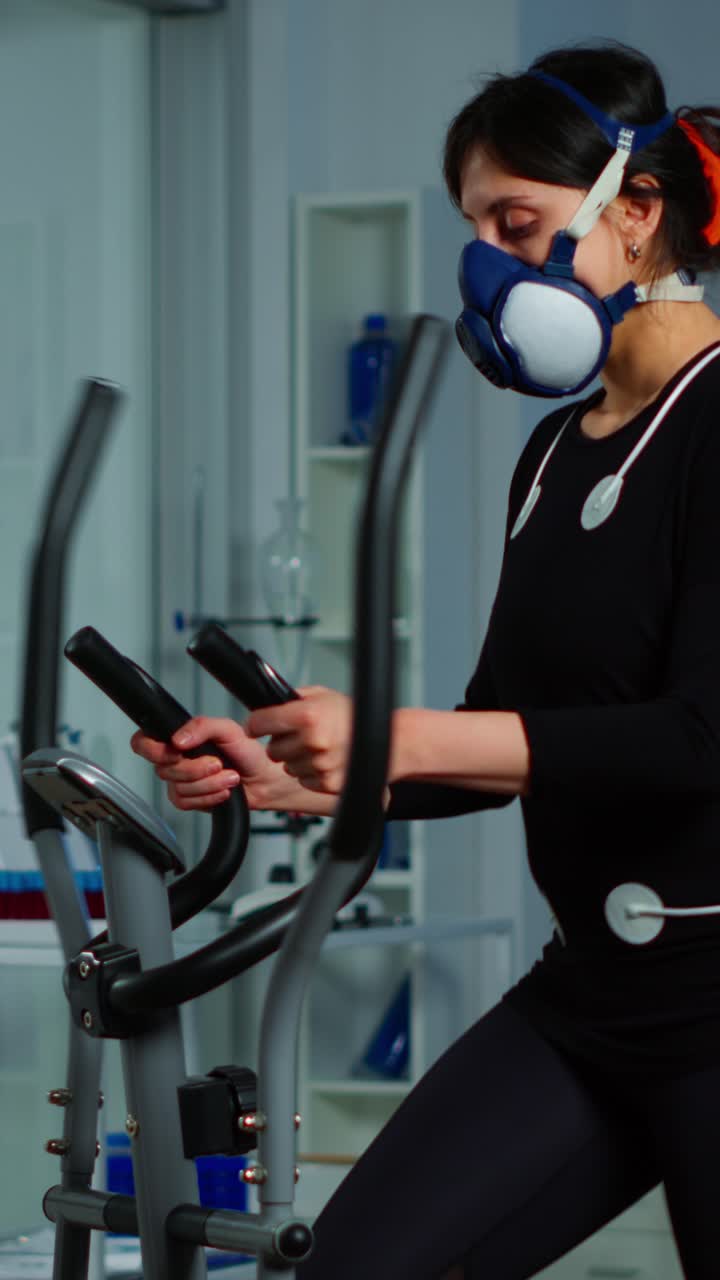 Woman undergoing physiological fitness testing with mask and sensors in a laboratory