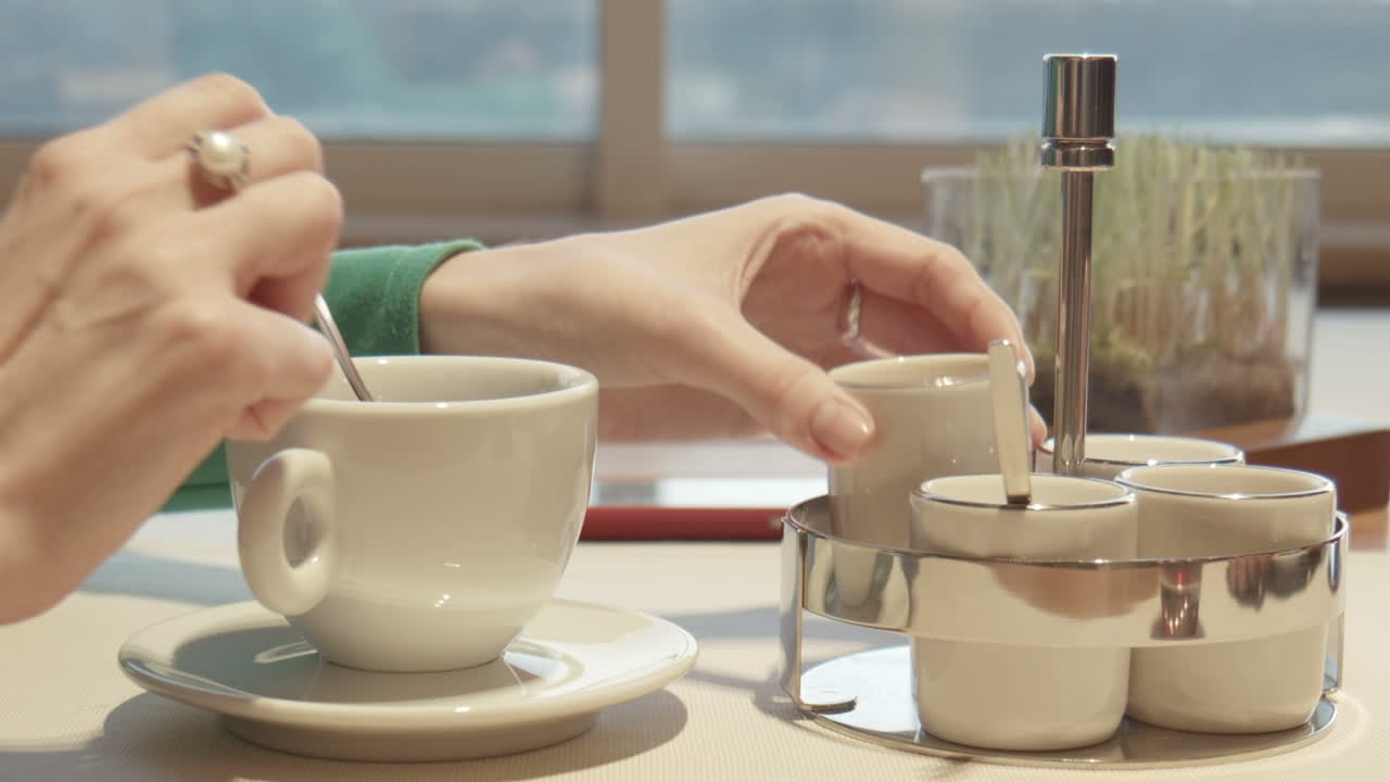 The Female Fills Sugar in Coffee and Stirs